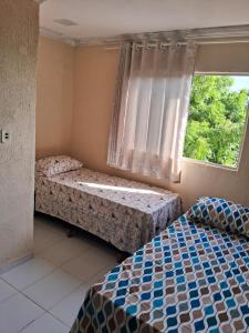 a bedroom with two beds and a window at Casa blue in Aracati