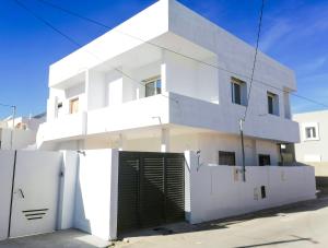 a white house with a gate in front of it at Villa Prestige sfax in Sfax
