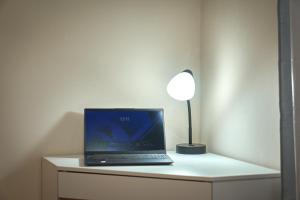 a laptop computer sitting on a desk with a lamp at Airport SJO Inn in Santiago Este