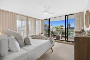 a bedroom with a white bed and a balcony at Albatross North Apartments in Gold Coast +236 photos