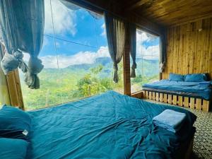 a bedroom with a bed and a large window at Mando Homestay in Bắc Yên