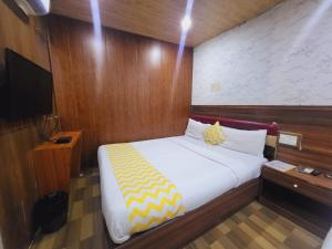 a bedroom with a large bed with a yellow and white blanket at Airport Inn Residency Mumbai in Mumbai +11 photos