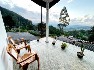 a patio with chairs and potted plants on a roof at Village Breeze Villa in Haputale