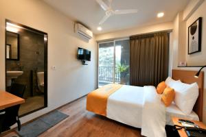 a hotel room with a bed and a bathroom at Hotel Banzai Rooms in Nashik