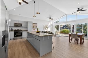 a kitchen with white cabinets and a dining room with a table at The Point 23 At Playa Avellanas in Playa Avellana