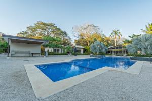 a swimming pool in front of a house at The Point 23 At Playa Avellanas in Playa Avellana