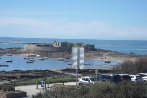 a group of cars parked in a parking lot near the ocean at Apt 4 pers - Magnifique vue mer - Terrasse - 50 m de la plage - Bleuenn in Le Fort-Bloqué