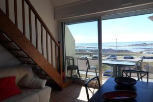 a living room with a couch and a table and a balcony at Apt 4 pers - Magnifique vue mer - Terrasse - 50 m de la plage - Bleuenn in Le Fort-Bloqué