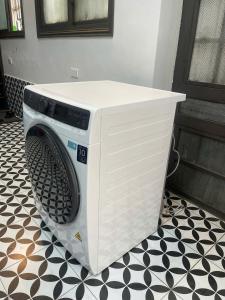 a white washing machine sitting on a black and white floor at Hotel Hc Luxury Apartment in Hanoi