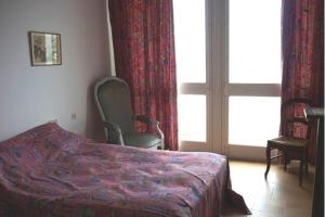 - une chambre avec un lit, une chaise et une fenêtre dans l'établissement Maison 6 personnes sur la plage - Vue mer exceptionnelle - TARA, à Pen-Palud