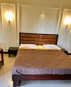 a bed in a room with two lights on the wall at River View Mangalore in Mangalore