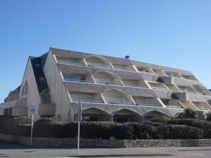een groot wit gebouw met veel ramen bij Apt 4 à 5 personnes magnifique vue mer, terrasse - 50 m de la plage -MELWENN in Le Fort-Bloqué