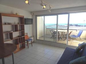 een woonkamer met uitzicht op een tafel en stoelen bij Apt 4 à 5 personnes magnifique vue mer, terrasse - 50 m de la plage -MELWENN in Le Fort-Bloqué