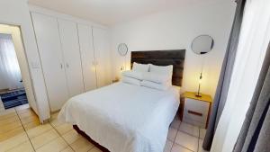 a bedroom with a bed with white sheets and pillows at Noordhang Nest in Four Ways