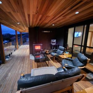 a living room with leather furniture and a fireplace at Prosser River view from Paradise in Orford