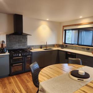 a kitchen with a table and a stove and a window at Prosser River view from Paradise in Orford
