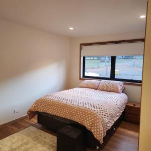 a bedroom with a bed and a large window at Prosser River view from Paradise in Orford