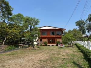 a house with a fence in front of it at Ban Buarawong บ้านบัวระวงค์ in Ban Nong Faek