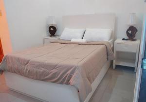 a bedroom with a bed with two night stands and two lamps at Tayud Hotel by Hiverooms in Liloan