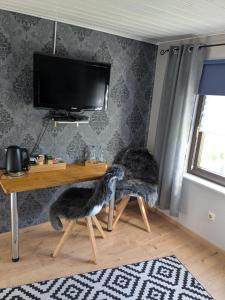 a cat sitting on a chair in front of a desk at Eva's Home in Müllenbach