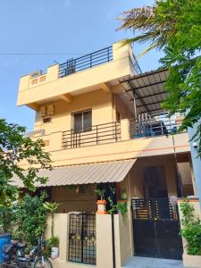 a large yellow building with a balcony at Vinayaka Homestay Hampi in Hampi