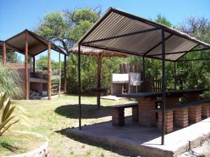 a pavilion with a picnic table in a garden at Hosteria Santa Francisca in Villa Cura Brochero