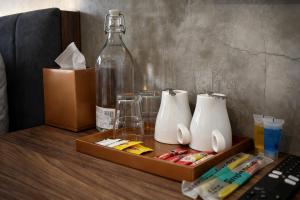 a table with a bottle and two mugs on it at Muari Boutique Hotel in Muar