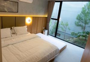 a bedroom with a large bed and a large window at Manse 만세 Villa in Ciburial