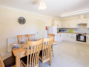 a kitchen and dining room with a wooden table and chairs at Dawson Park 6 - Uk12665 in Mablethorpe