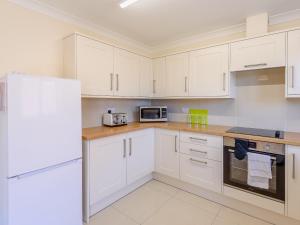a kitchen with white cabinets and a white refrigerator at Dawson Park 6 - Uk12665 in Mablethorpe +10 photos