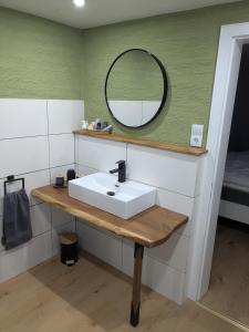 a bathroom with a sink and a mirror at Eva's Home in Müllenbach +16 photos