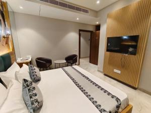 a hotel room with a bed and a tv at Hotel Eastleigh in Ludhiana