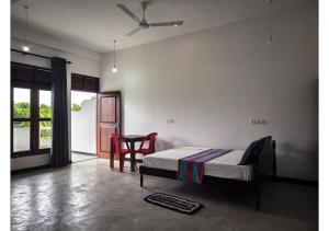 a bedroom with a bed and a table and chairs at Thotupola Villa - Mirissa in Mirissa