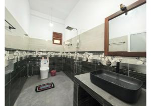 a bathroom with a black sink and a toilet at Thotupola Villa - Mirissa in Mirissa +87 photos