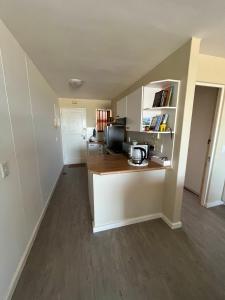 an empty room with a kitchen and a living room at Sea Spray B103 in Cape Town