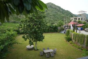 a park with a table and chairs and a tree at Cozy Cliff By Marwar Royal in Thūr