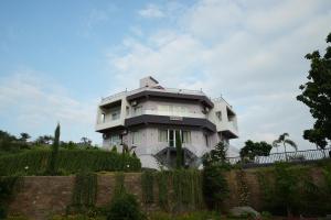 a white house on a hill with a fence at Cozy Cliff By Marwar Royal in Thūr