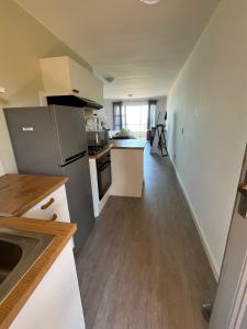 a kitchen with white cabinets and a refrigerator at Sea Spray B103 in Cape Town