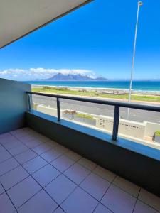 a balcony with a view of the beach and the ocean at Sea Spray B103 in Cape Town