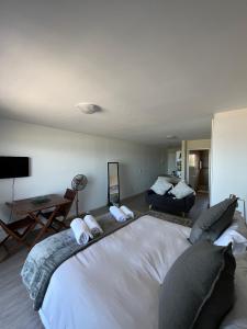 a large white bed in a room with a couch at Sea Spray B103 in Cape Town +10 photos