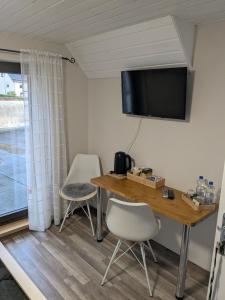 a room with a table and two chairs and a television at Eva's Home in Müllenbach