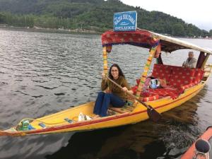 a woman sitting on a boat in the water at La Barca Zaindari in Srinagar