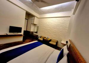 a hotel room with a bed and a flat screen tv at Stays - Golf Course Road in Gurgaon
