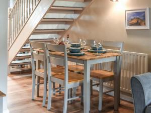 a dining room table and chairs under the stairs at Gable End Cottage in Ingleton