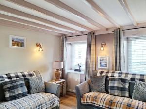 a living room with two couches and a table at Gable End Cottage in Ingleton