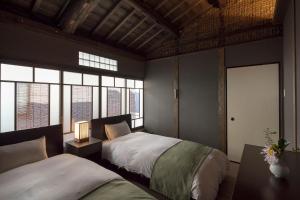 Un pat sau paturi într-o cameră la Sumitsugu Machiya House