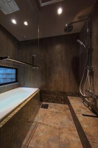 La grande salle de bains est pourvue d'une baignoire et d'une douche. dans l'établissement Sumitsugu Machiya House, à Kyoto