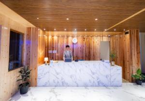 a man standing in an office with a large marble desk at Wisteria Crystal Manor in Pelling
