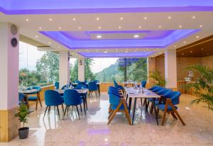 a dining room with blue chairs and tables at Wisteria Crystal Manor in Pelling