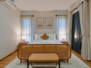 a bedroom with a bed and a rattan bench at Solune Khaoyai Pool Villa in Ban Rai Khlong Sai +8 photos